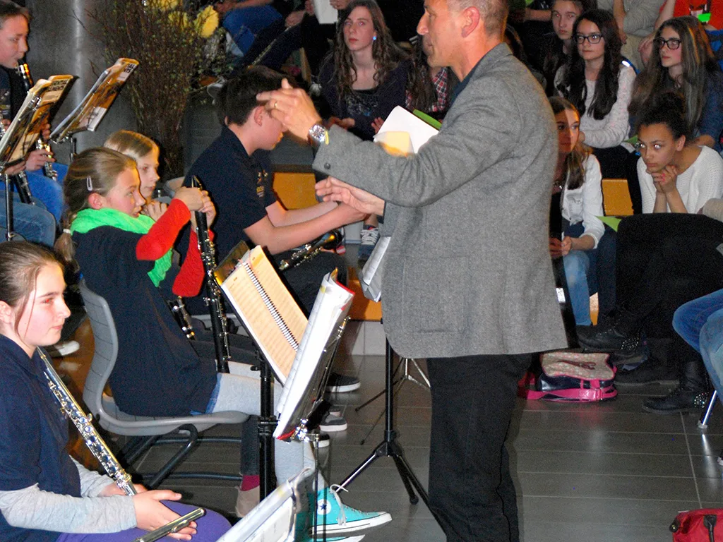 Person dirigiert das Orchester im Foyer.
